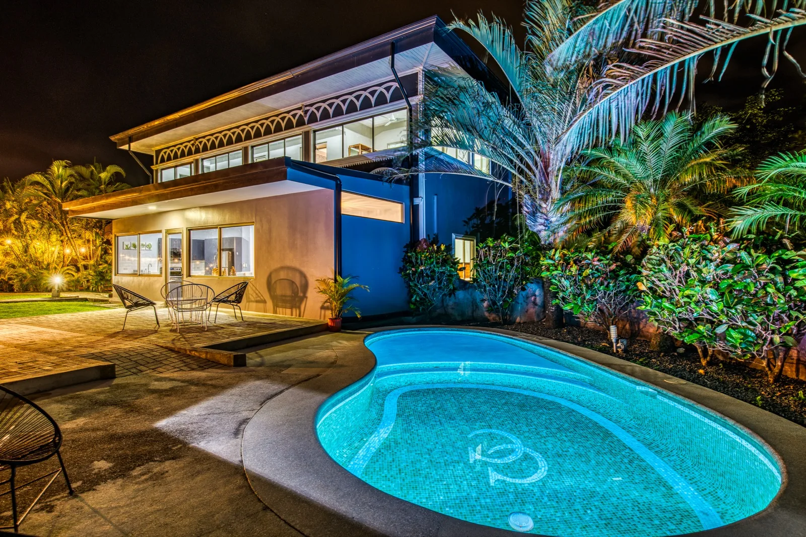 The pool glowing at night beside the villa