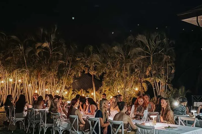 Candlelit outdoor group dining under palm trees at Castillo Colonial Nosara