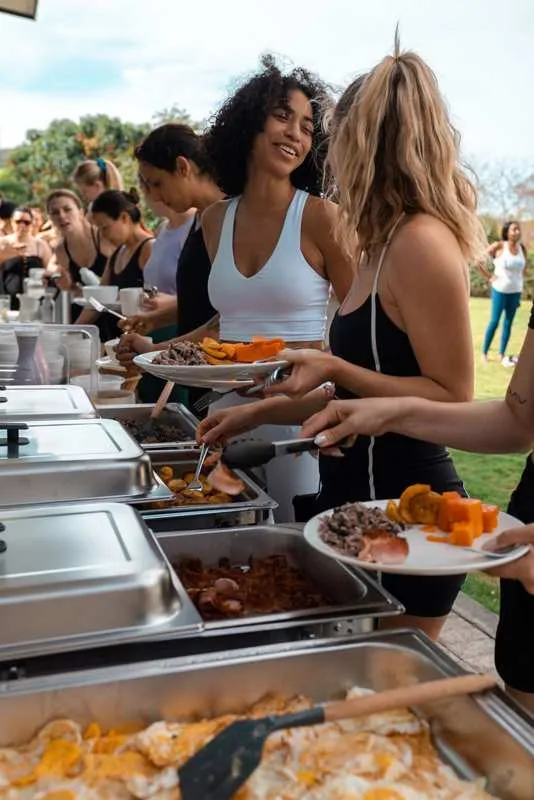 Guests serving performance-style buffet plates at Castillo Colonial Nosara