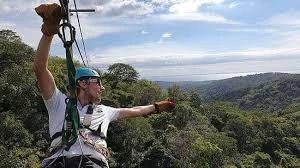 Ziplining over the jungle canopy with an ocean view