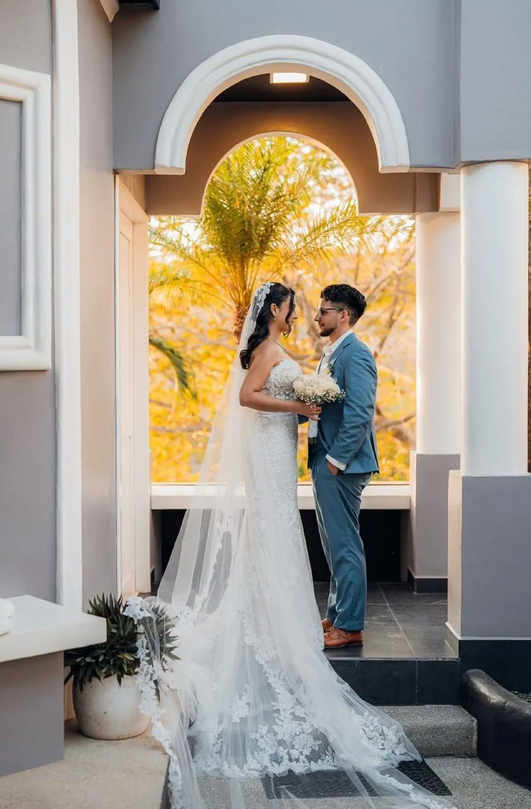 Couple beneath the colonial arch at golden hour